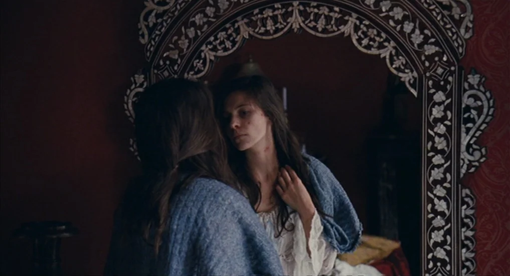 House of Tolerance (2011) movie still: medium — An interior bedroom features dark red damask wallpaper and an ornate, mother-of-pearl inlaid mirror.…