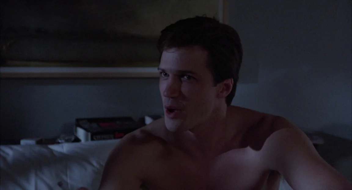 Creepshow 2 (1987) movie still: medium — A dimly lit room with a framed painting hanging on the wall above the bed. The shirtless man sits up in bed…
