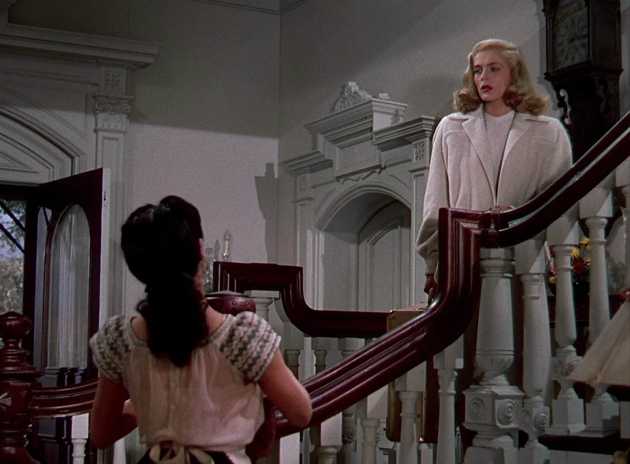 Desert Fury (1947) movie still: medium — An interior staircase landing features white paneled walls and a tall wooden clock. One woman with a…