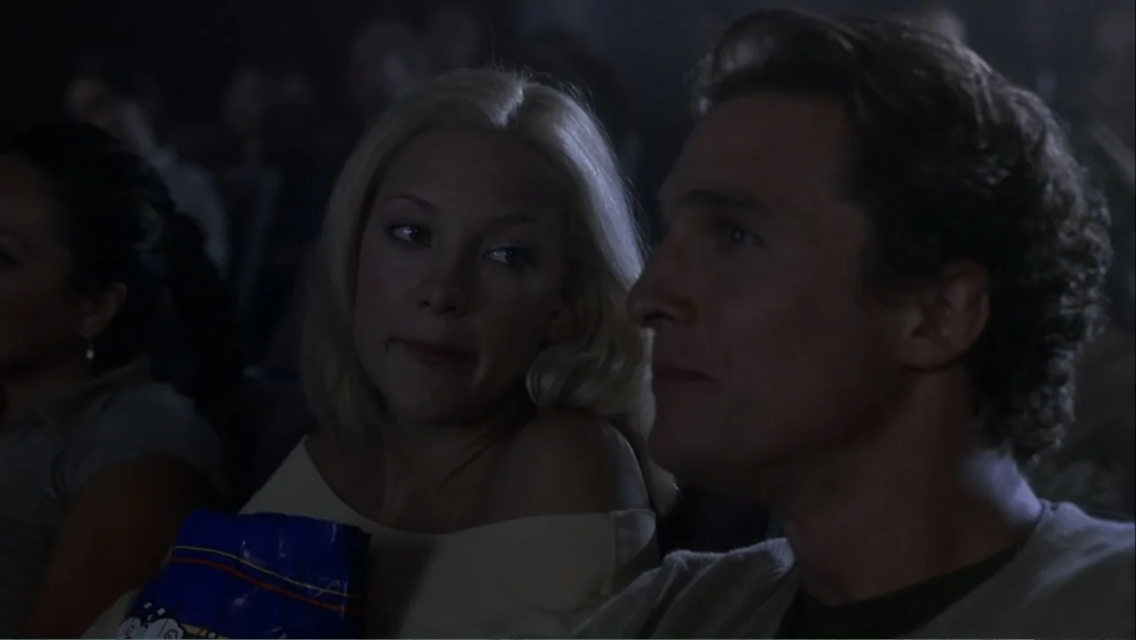 How to Lose a Guy in 10 Days (2003) movie still: medium — A dark movie theater auditorium with rows of seats occupied by an audience. A woman and a…