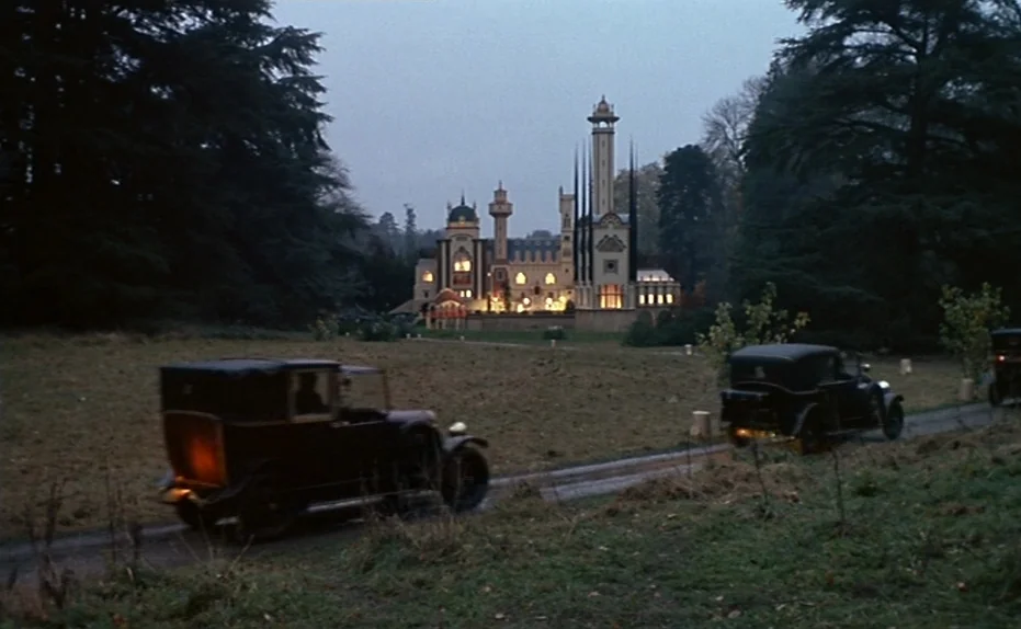 Life Is A Bed of Roses (1983) movie still: establishing — A grand, multi-towered estate building stands in the distance at the end of a path. Two…