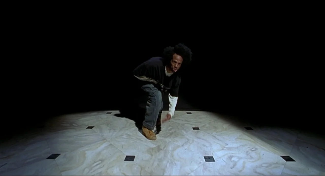 Scary Movie 2 (2001) movie still: fullbody — A dark, empty performance space features a patterned marble floor lit by one spotlight. A man in…