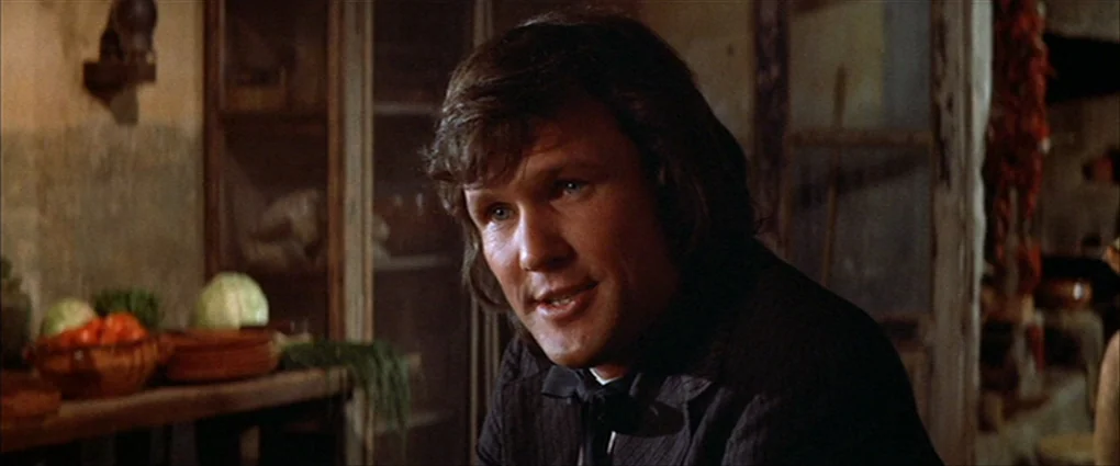 Pat Garrett & Billy The Kid (1973) movie still: medium — A rustic, dimly lit cellar interior features wooden shelves holding produce like cabbages.…