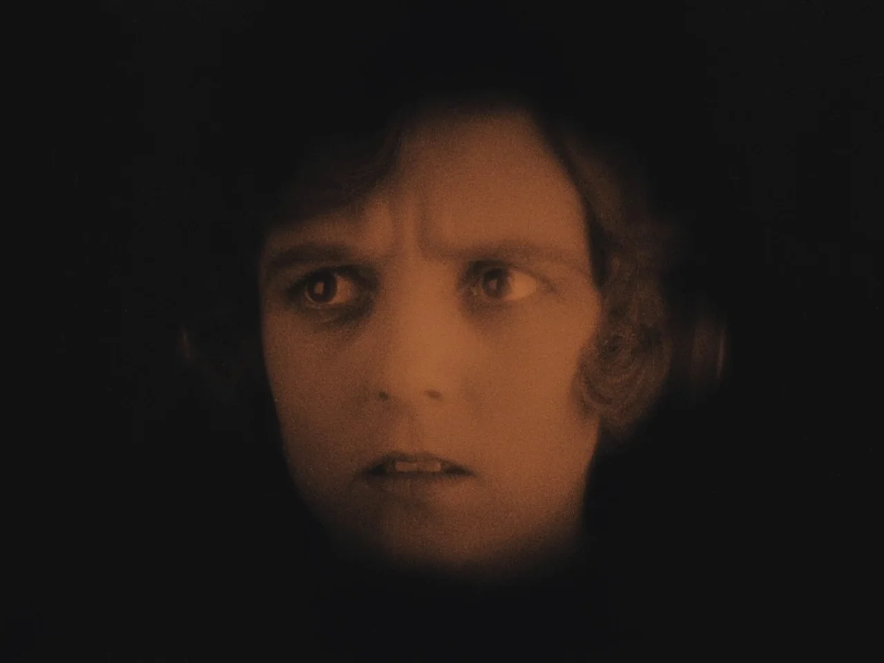 The Lodger (1927) movie still: closeup — A dark environment with no visible background details. The woman looks away from the camera.