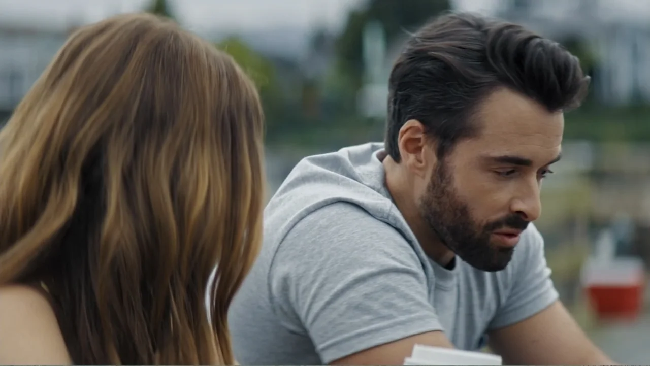 Making Waves (1998) movie still: medium — An outdoor area with blurred greenery in the background under an overcast sky. A man with a beard and a…