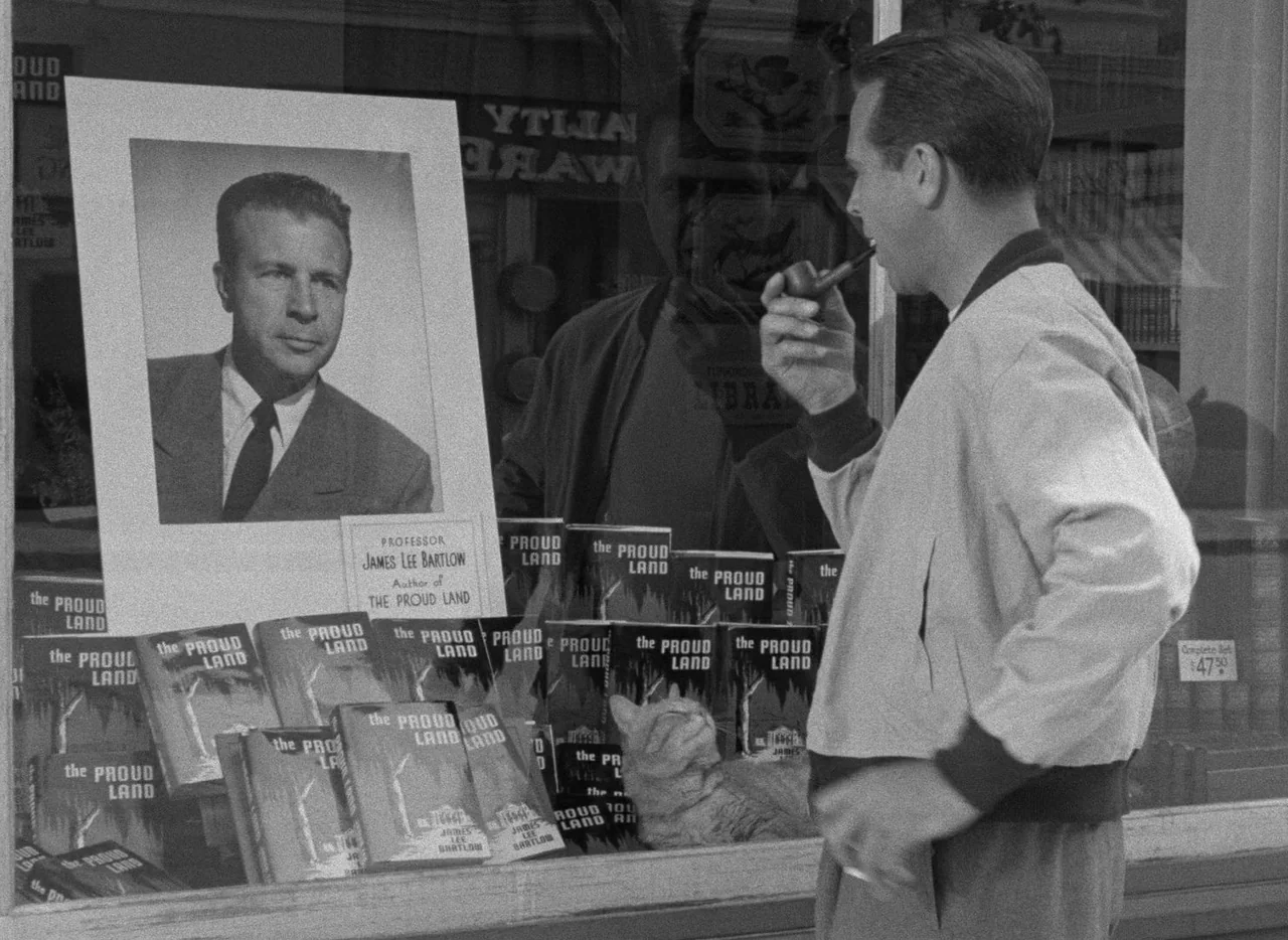 The Bad and the Beautiful (1952) movie still: medium — A man observes a window display filled with numerous copies of a specific book. A large…