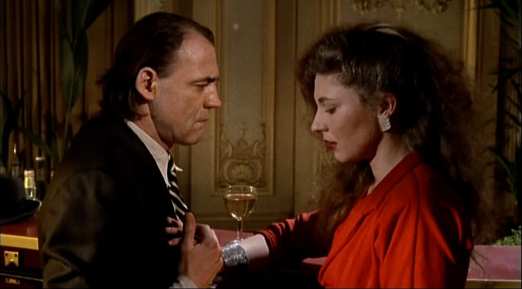 Wings Of Desire (1987) movie still: medium — A dimly lit, wood-paneled room features decorative wall molding and a wine glass. A man and a woman…