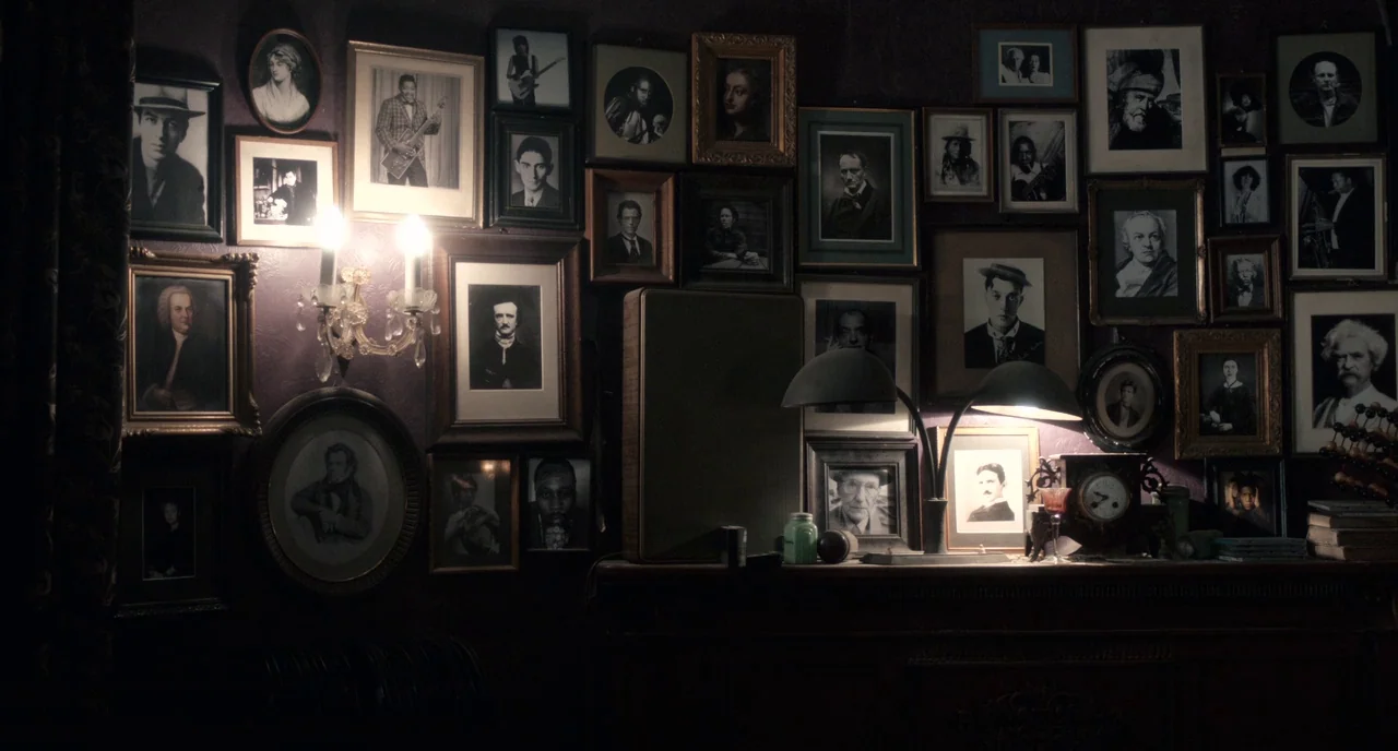 Only Lovers Left Alive (2013) movie still: establishing — A dark wall is covered with numerous framed portraits and photographs of people. A wooden…