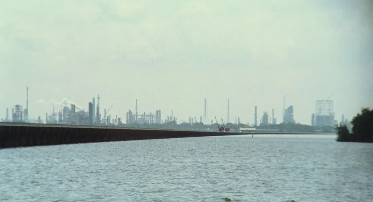 Beasts Of The Southern Wild (2012) movie still: establishing — A long bridge stretches across a wide body of water toward a distant industrial…