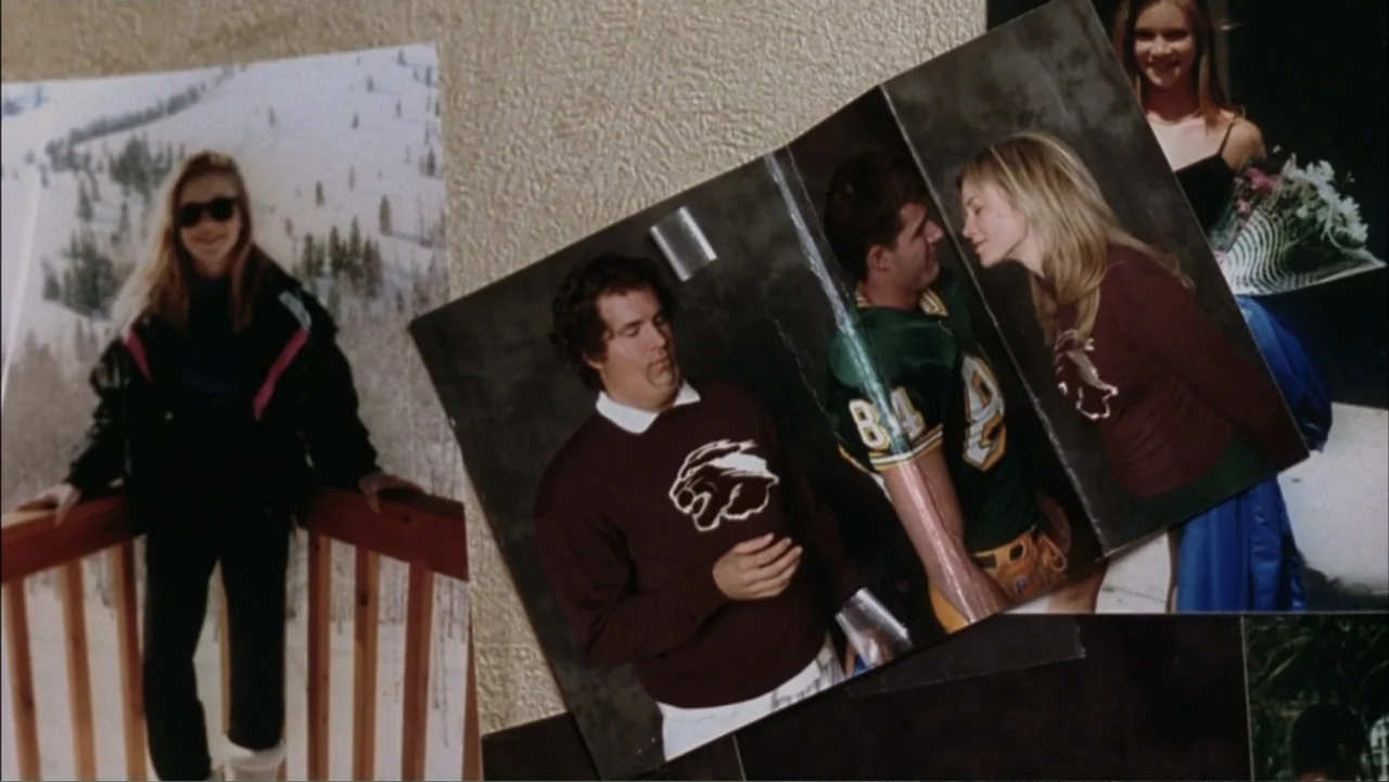 Just Friends (2005) movie still: closeup — A collection of assorted printed photographs are taped to a textured off-white wall. The images show a…