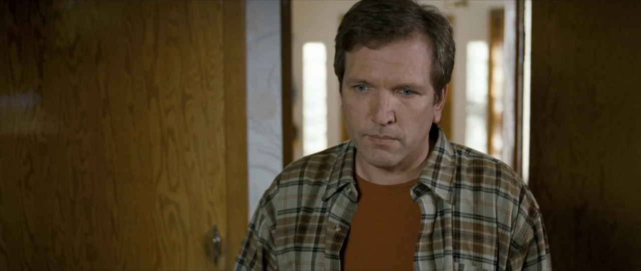The Haunting in Connecticut (2009) movie still: medium — A man stands in an interior hallway with wooden doors and beige walls. The subject is…