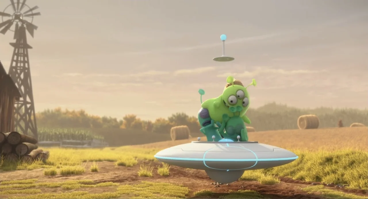 Luis and the Aliens (2018) movie still: wide — A rural farmland with a wooden windmill and hay bales rests under a hazy sky. Three small green alien…