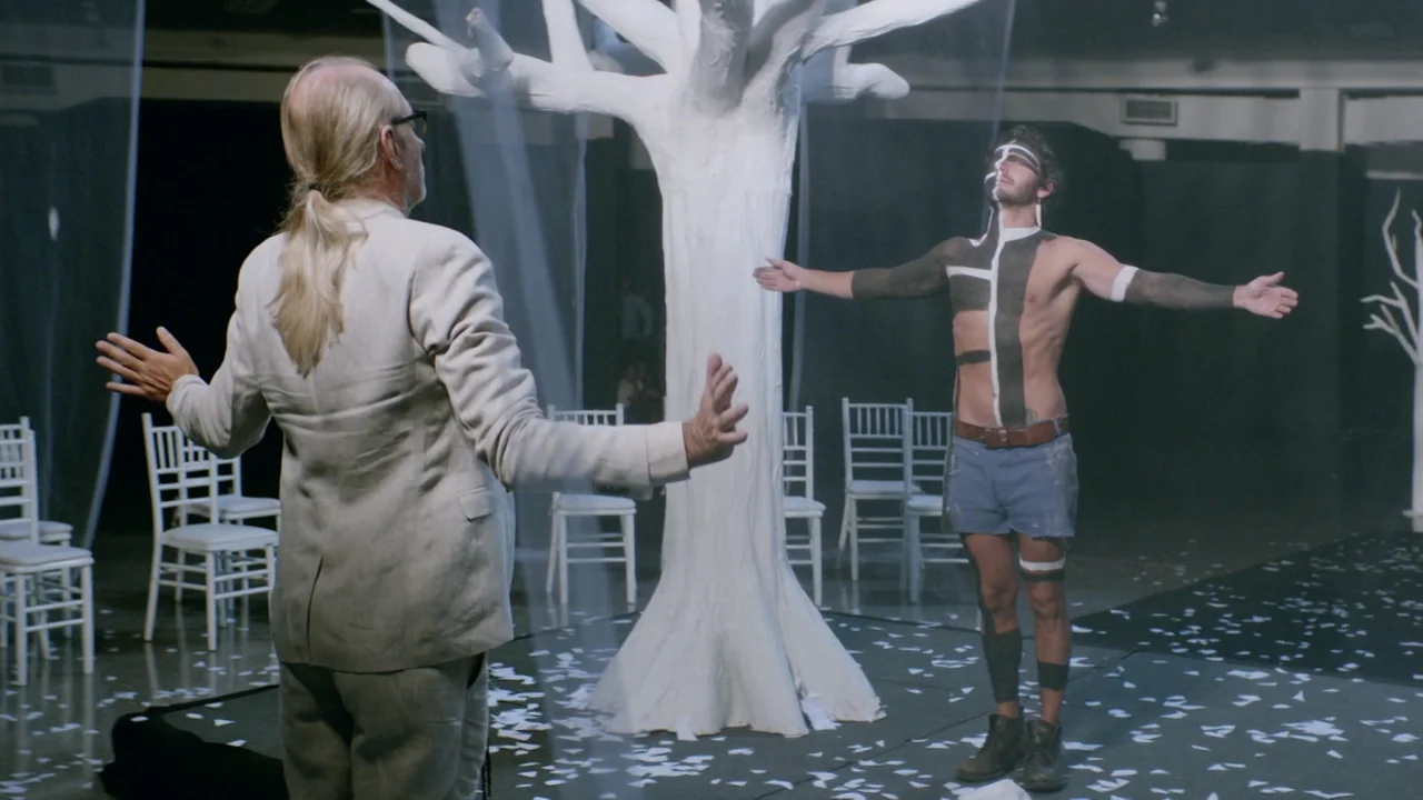 That's Not Cheating (2016) movie still: fullbody — A spacious room contains a large white artificial tree and several white wooden chairs. An older…