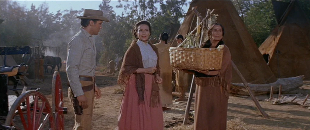 Flaming Star (1960) movie still: medium — A rural settlement features several canvas teepees situated in a dusty outdoor area. A man in western…