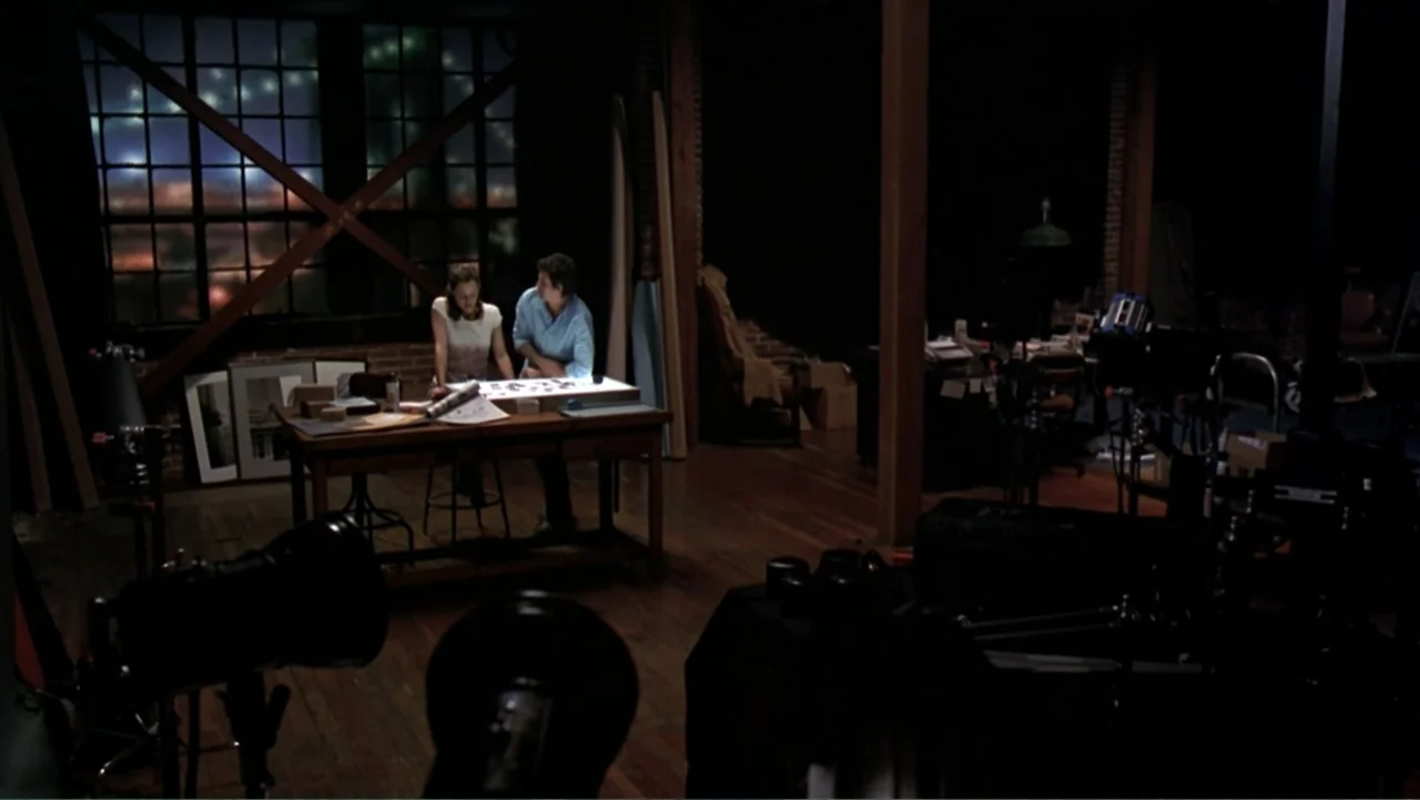13 Going on 30 (2004) movie still: wide — A dark, spacious studio features wooden floors and a large window looking out at night. A man and a woman…