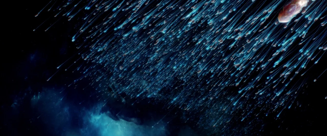 Lucy (2014) movie still: establishing — Deep space is filled with a dense, directional swarm of glowing blue light streaks. The streaks move…