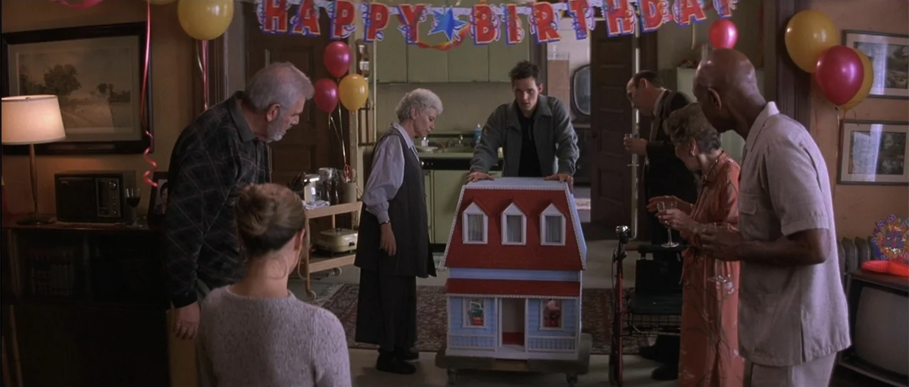 The Wedding Planner (2001) movie still: medium — A living room decorated with colorful balloons and a birthday banner hangs overhead. A diverse…