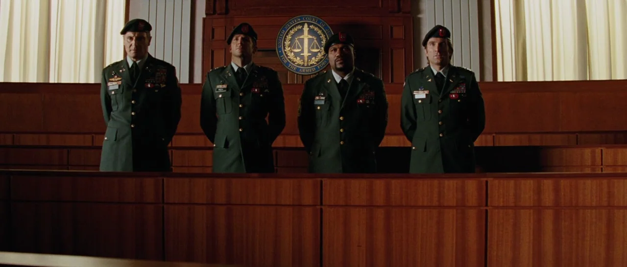 The A-Team (2010) movie still: medium — Four soldiers in dress uniforms stand side-by-side in front of a wooden wall. A circular seal of the United…