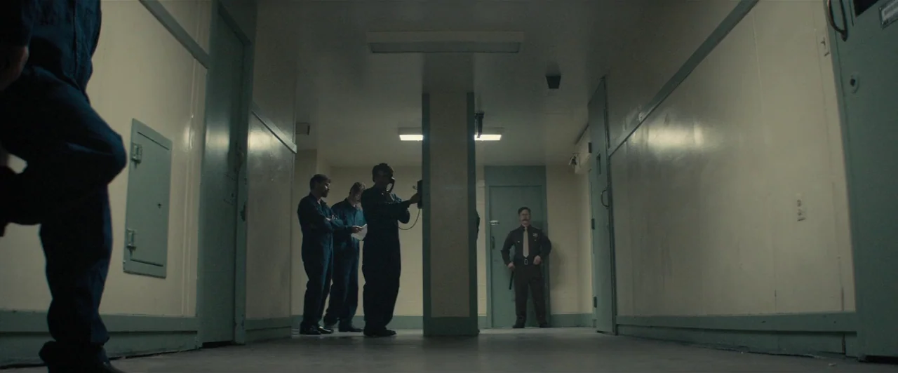 Extremely Wicked, Shockingly Evil and Vile (2019) movie still: wide — A utilitarian institutional hallway with pale walls and dark metal door…