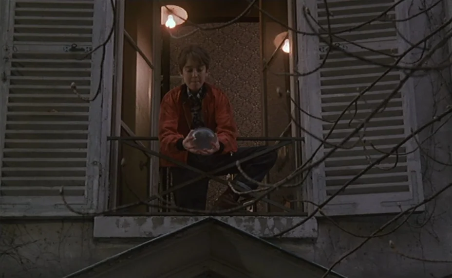 Kung Fu Master! (1988) movie still: medium — A teenager crouches on a small iron-railed balcony of a building with white wooden shutters. He holds a…