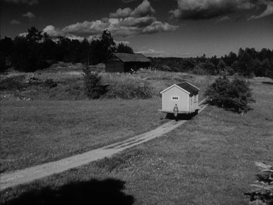 It Rains On Our Love (1946) movie still: wide — A rural landscape features a dirt path winding through open grass and scattered trees. A small…