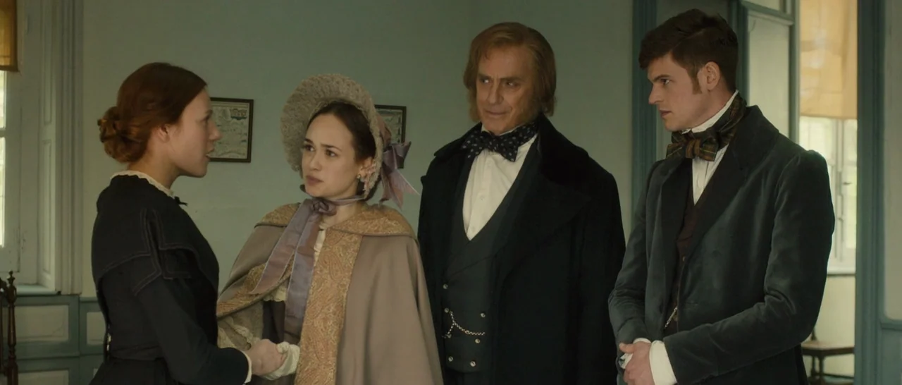 A Quiet Passion (2016) movie still: medium — A well-lit room features soft-toned walls decorated with small framed maps. Four people in 19th-century…