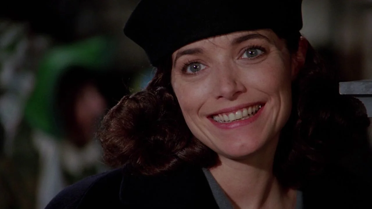 Scrooged (1988) movie still: closeup — A woman wearing a dark beret is shown in a tight close-up frame. She is looking slightly off-camera with a…