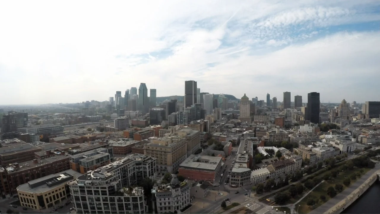Alex & Emma (2003) movie still: establishing — A wide aerial view of a dense metropolitan cityscape under a partially cloudy sky. Numerous high-rise…