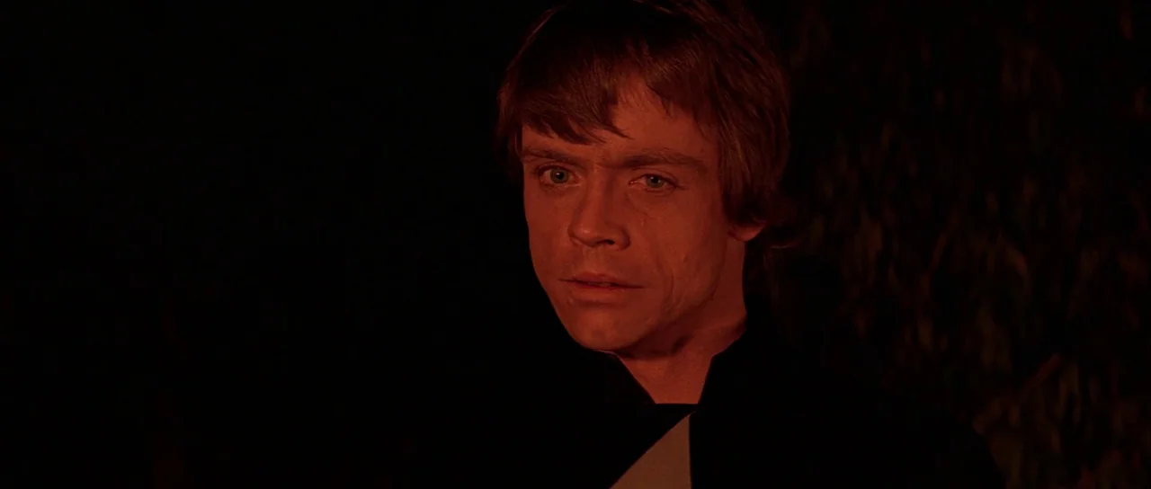 Return Of The Jedi (1983) movie still: closeup — A man is shown in a dark outdoor setting at night. He is illuminated by a deep red light source.