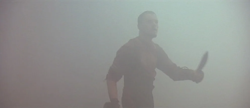 Gangs of New York (2002) movie still: medium — A man stands within an dense, all-encompassing fog that obscures the background entirely. He holds a…