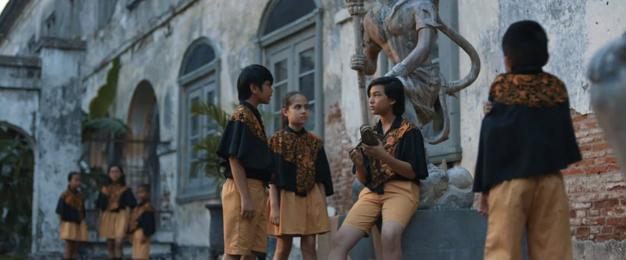 The Chanting 3 (2008) movie still: medium — A group of children in matching capes stand before an old stone building wall. Three children in the…
