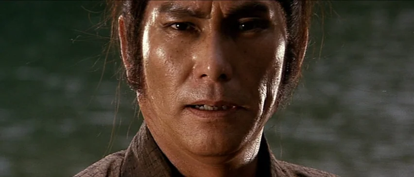 Lone Wolf and Cub: Baby Cart in the Land of Demons (1973) movie still: closeup — A close up view of an east asian man against a blurred outdoor…