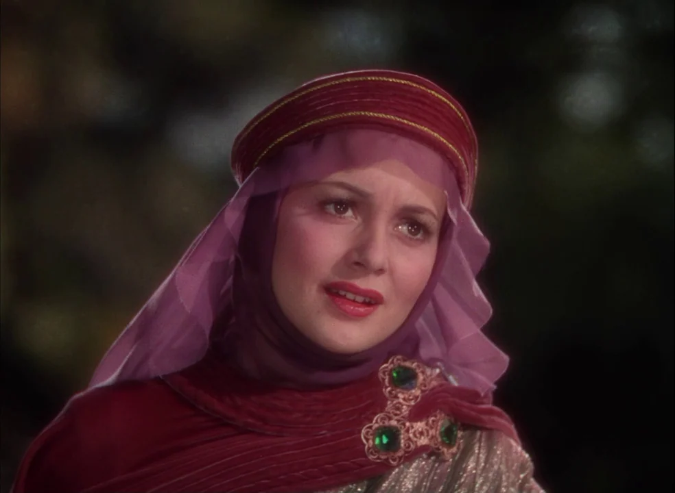 The Adventures of Robin Hood (1938) movie still: closeup — A dark forest background creates a high-contrast environment behind a person in costume.…