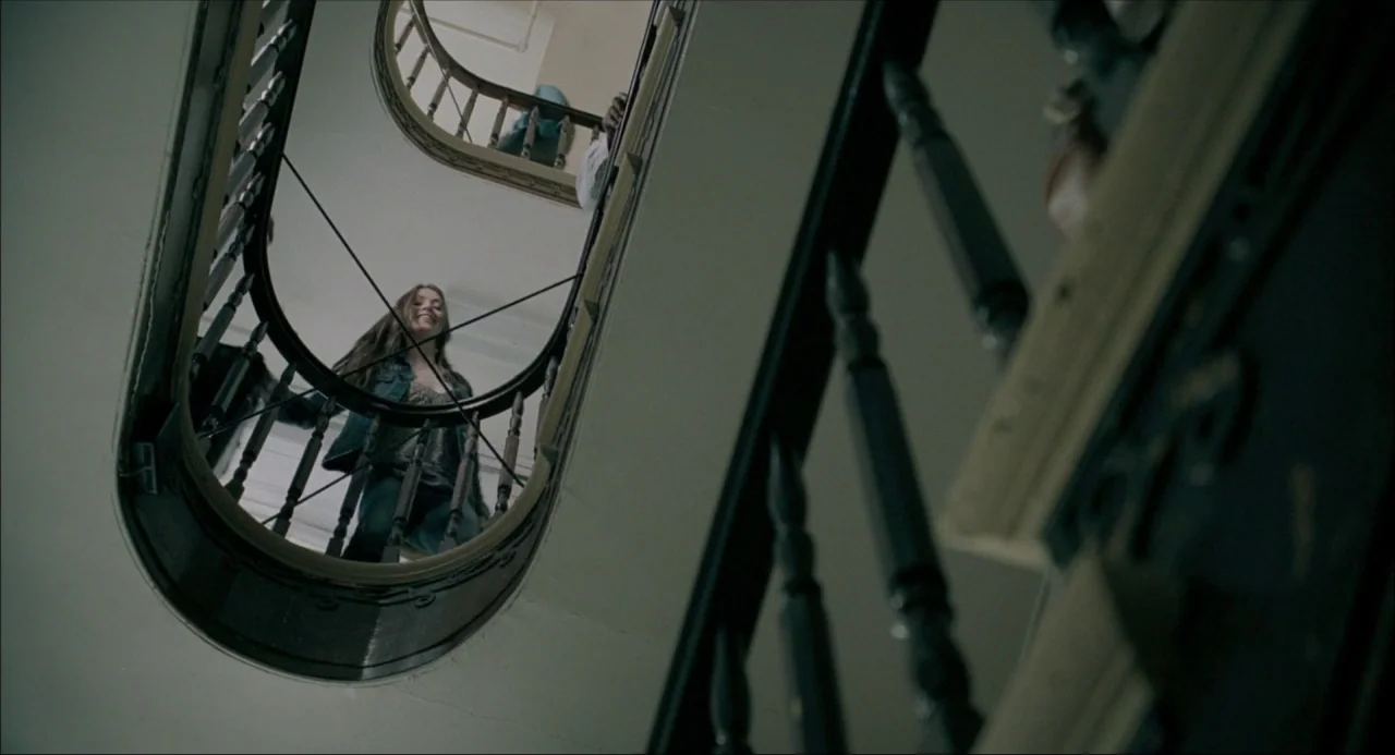 The Moth Diaries (2011) movie still: medium — A view looking up through a spiral staircase in a residential building. A young woman walks down the…