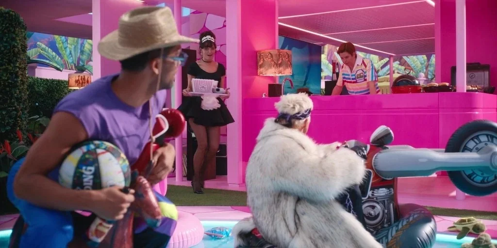 Barbie (2023) movie still: medium — A bright pink outdoor patio space features a swimming pool and modern structural elements. Two men interact…