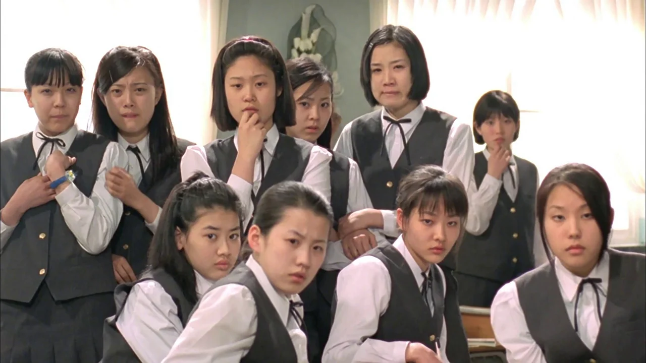 Whispering Corridors (1998) movie still: medium — A group of teenage girls in matching school uniforms sit together in a bright room. The subjects…