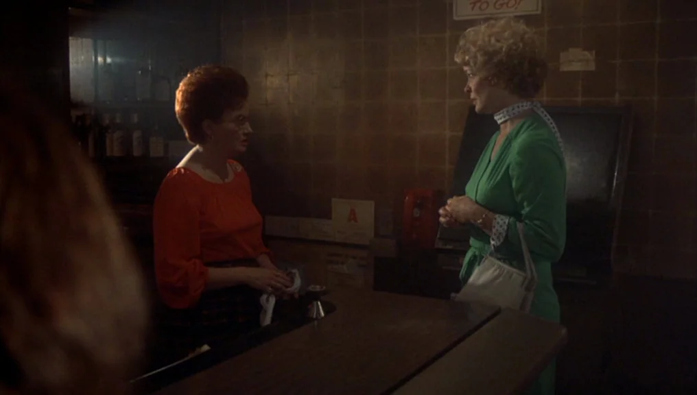 Alice Doesn’t Live Here Anymore (1974) movie still: medium — A dimly lit counter area features a brown tiled wall and a red wall phone. Two women…