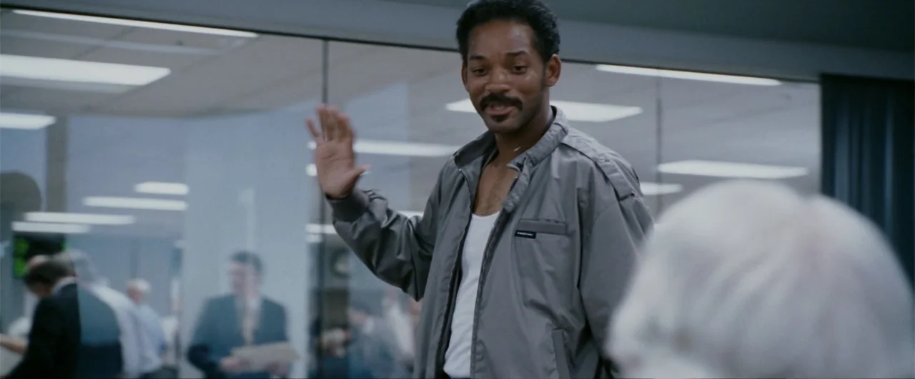 The Pursuit of Happyness (2006) movie still: medium — A modern, bright office interior with glass partitions and multiple employees in the…