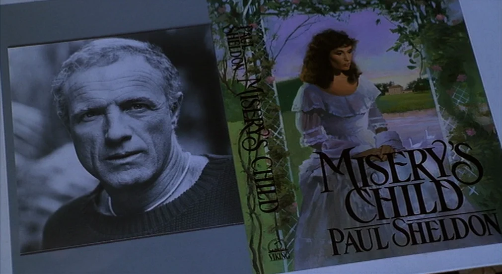 Misery (1990) movie still: closeup — A flat surface displays a black and white author portrait and a book cover. The book is titled Misery's Child…