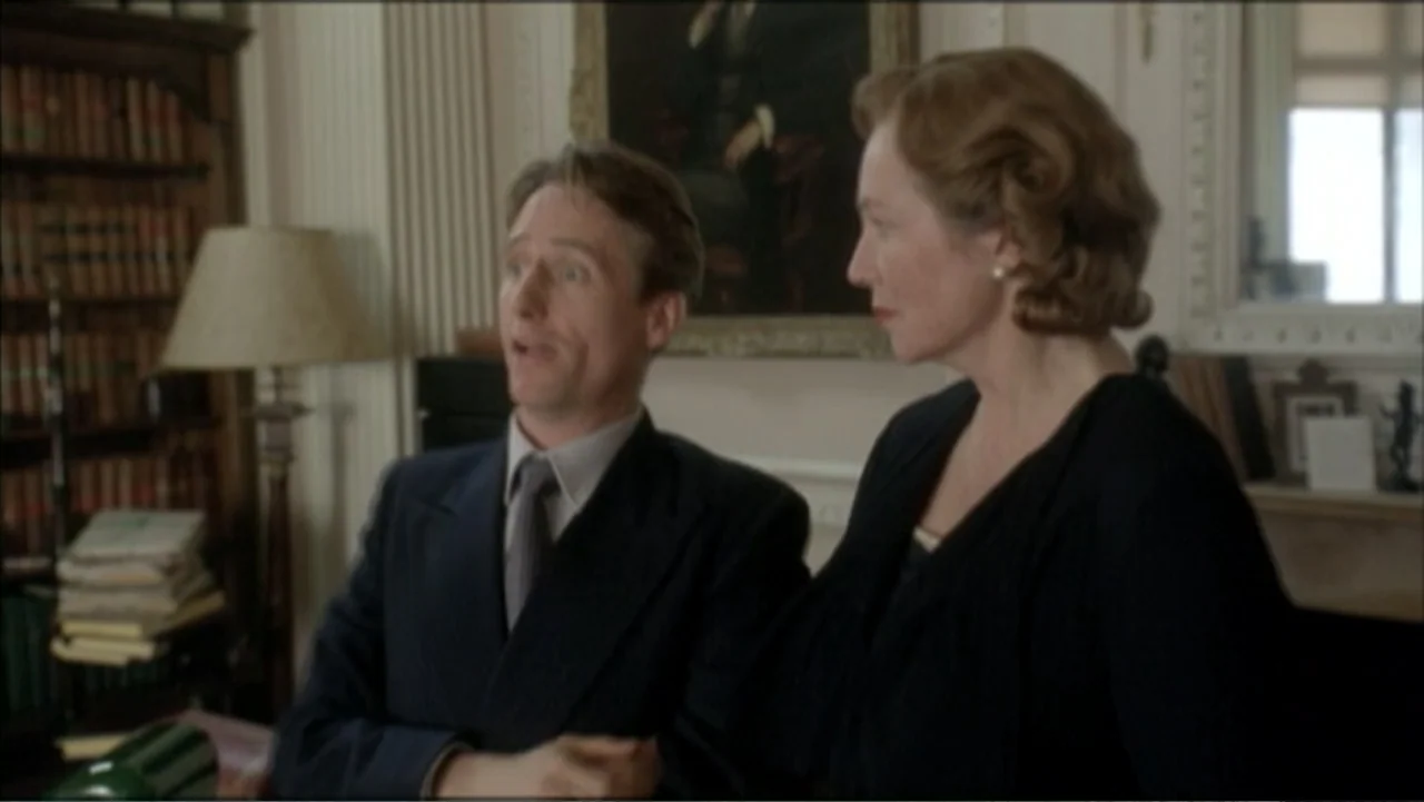 The Gathering Storm (2002) movie still: medium — A traditional wood-paneled study features floor-to-ceiling bookshelves and a classic oil painting…
