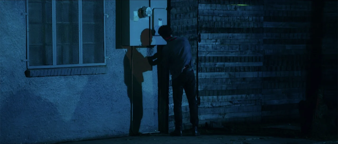 68 Kill (2017) movie still: medium — A man stands against a rough textured wall at night near an electrical meter. The man faces the wall and…