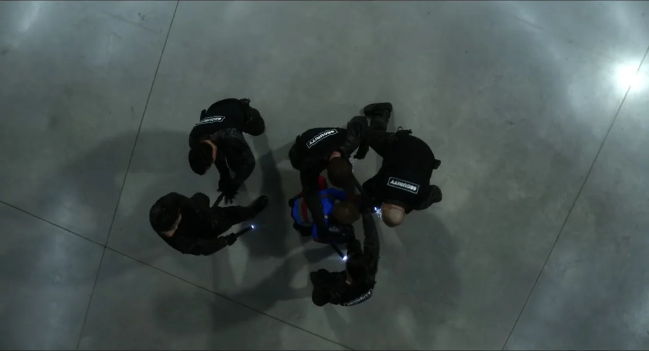 Henry Danger: The Movie (2025) movie still: wide — A vast, empty concrete floor illuminated from above in a sterile, industrial space. Several…