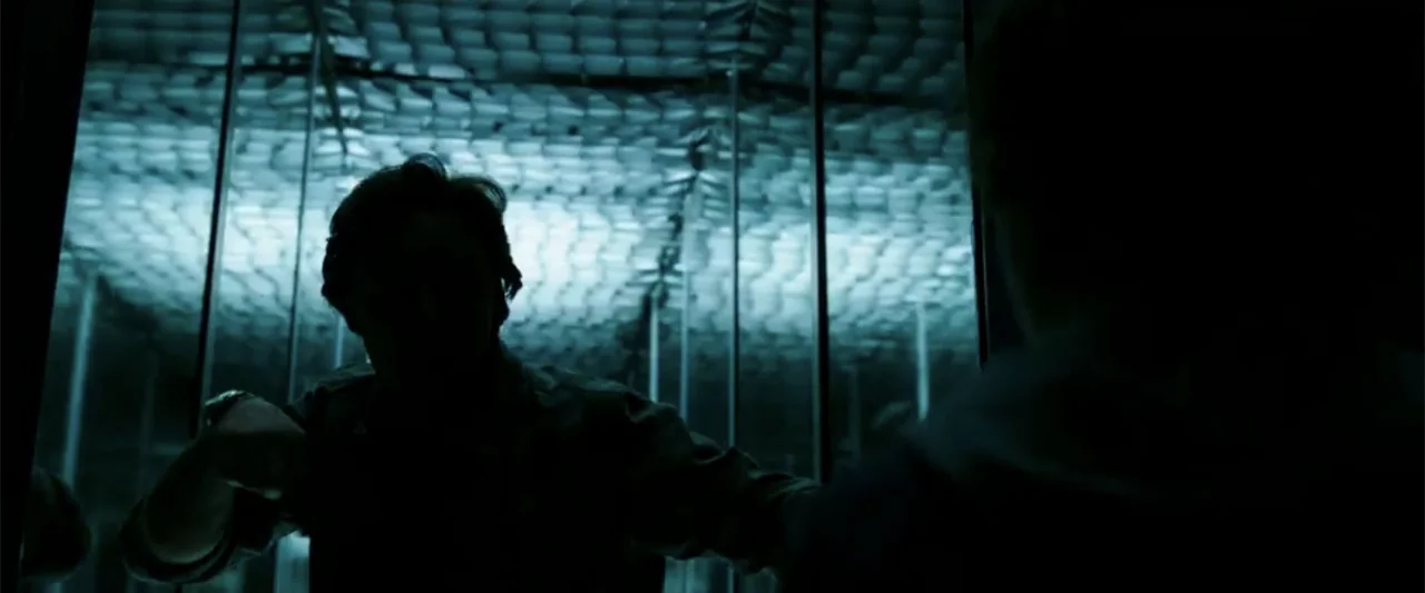 K.G.F: Chapter 2 (2022) movie still: medium — A modern metallic elevator interior with a grid-patterned ceiling panel illuminated by fluorescent…
