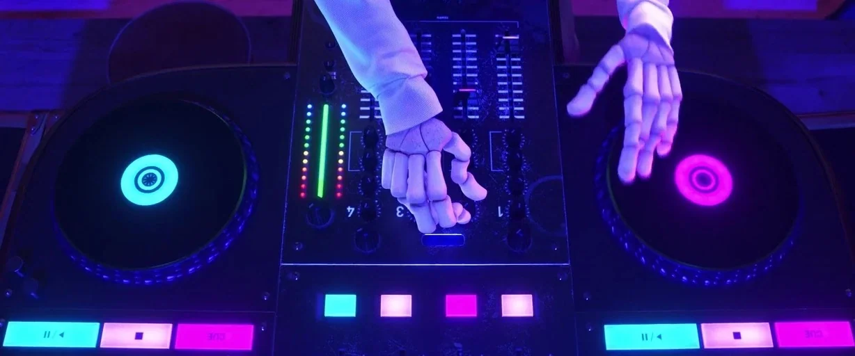 Coco (2017) movie still: closeup — A dark console with glowing buttons and faders dominates the center of the frame. Skeletal hands are posed over…