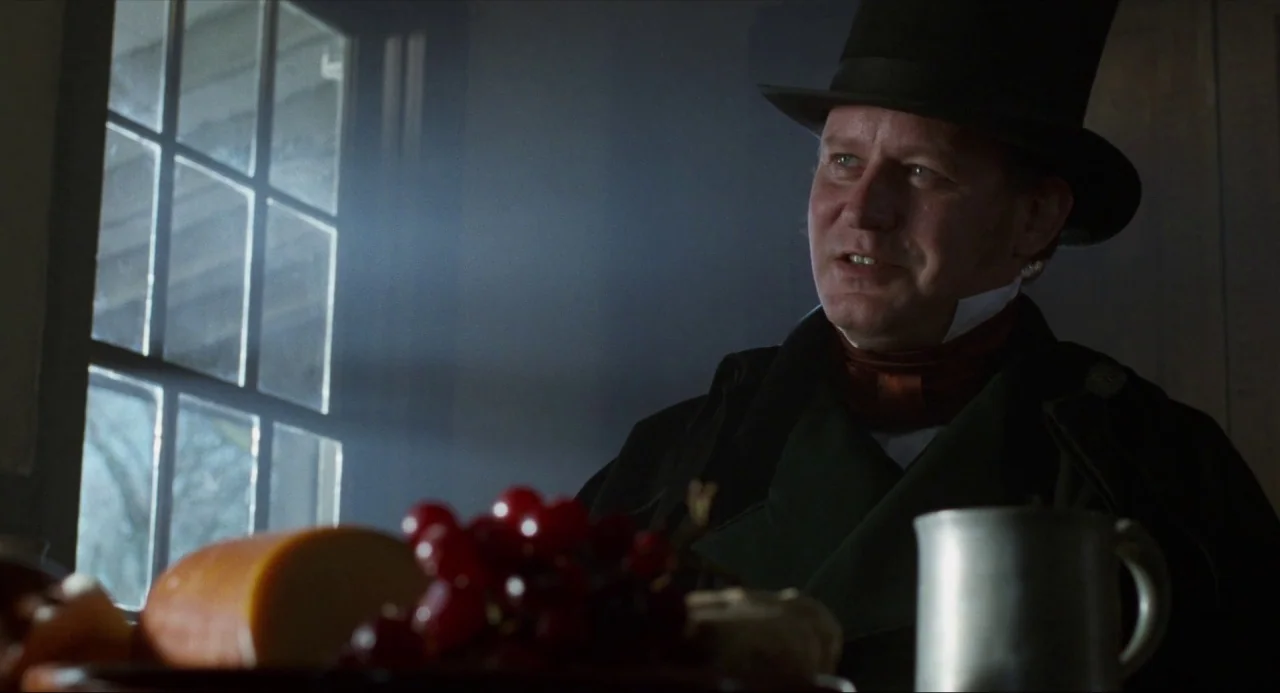 Amistad (1997) movie still: medium — An interior space features a man in nineteenth-century formal attire sitting near a window. A bowl of grapes…
