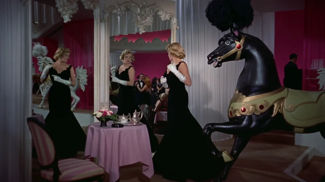White Christmas (1954) movie still: fullbody — A nightclub interior features a pink-clothed table and a large decorative black carousel horse. A…