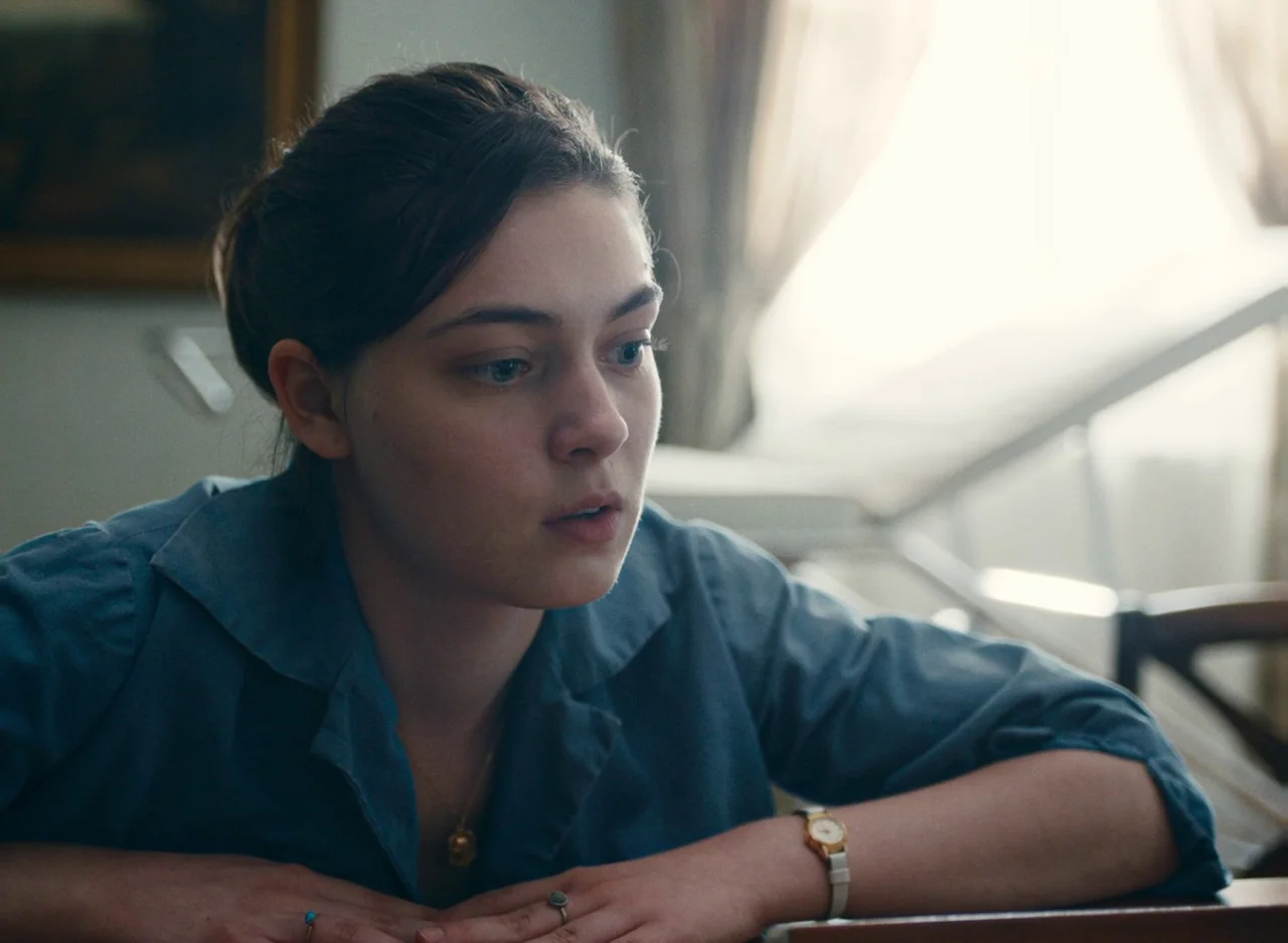 Happening (2021) movie still: A medium-closeup frames a young woman in thoughtful repose, her face illuminated by soft ambient light and a striking…