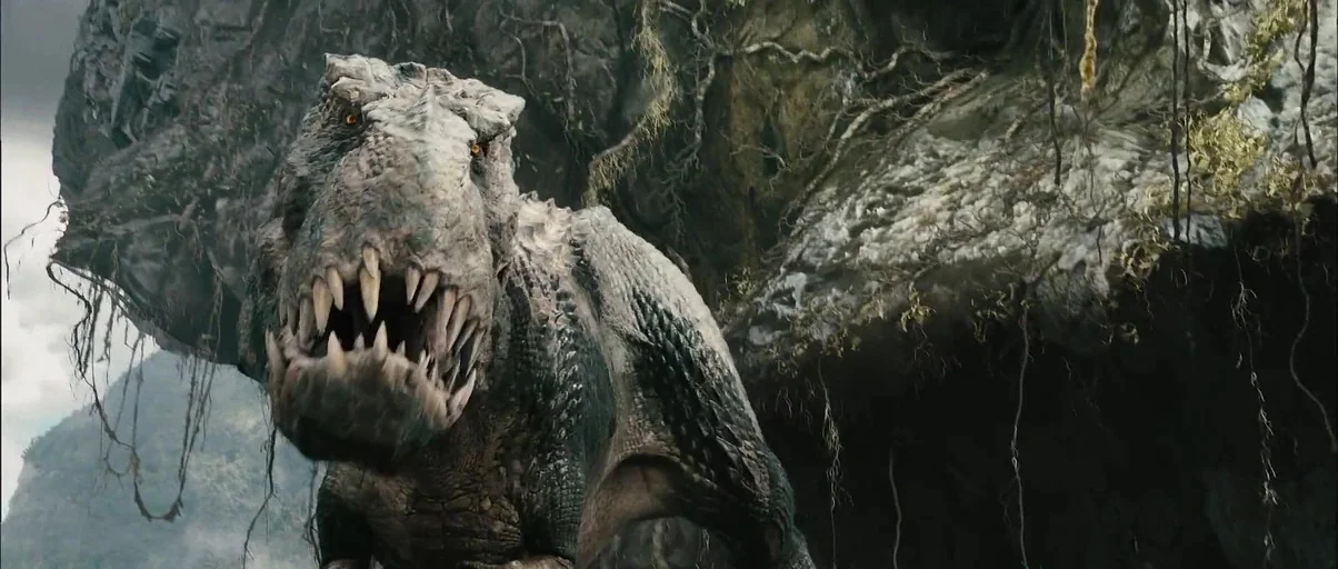 King Kong (2005) movie still: closeup — A rugged cliffside features heavy rock formations adorned with hanging moss and vines. A massive reptilian…