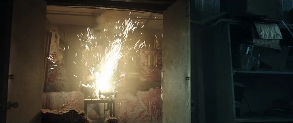 Abattoir (2016) movie still: wide — A cluttered workshop with stained walls and heavy doors framing the central work area. A metal cutting tool…