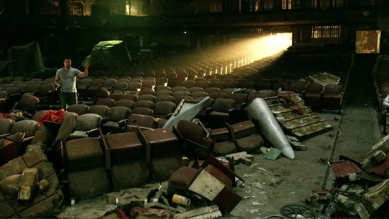 Transformers: Age of Extinction (2014) movie still: wide — A dilapidated, dusty theater interior features rows of damaged velvet seats covered in…